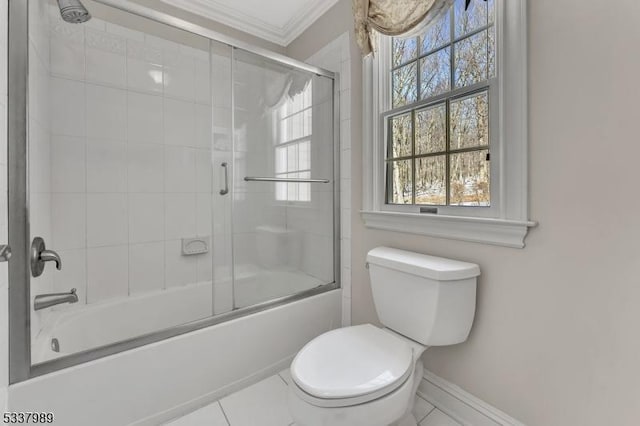 full bathroom with baseboards, crown molding, toilet, combined bath / shower with glass door, and tile patterned floors