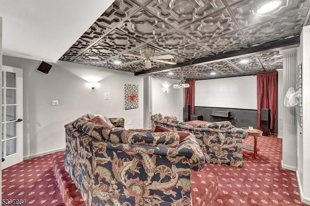 carpeted home theater featuring a ceiling fan, baseboards, and an ornate ceiling