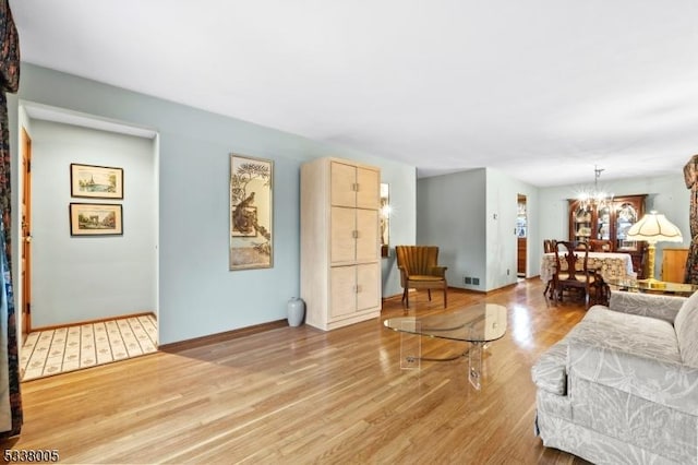 living room featuring a notable chandelier and light hardwood / wood-style floors