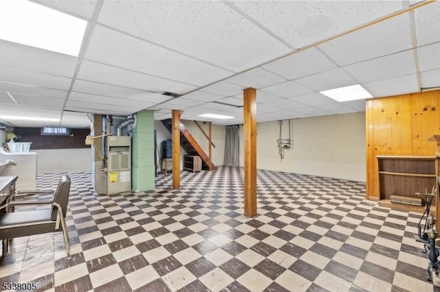 basement with heating unit and a paneled ceiling