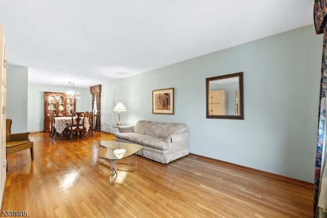 living room with light hardwood / wood-style flooring and a notable chandelier