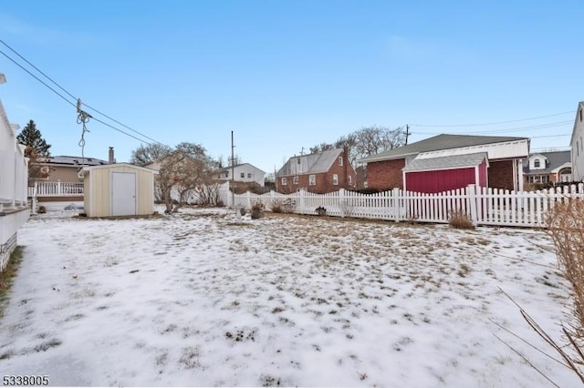 snowy yard with a storage shed