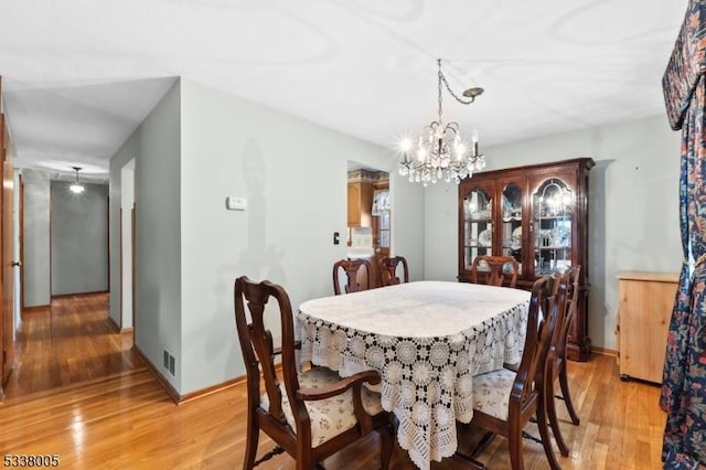 dining room featuring hardwood / wood-style flooring and an inviting chandelier