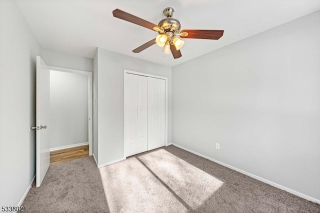 unfurnished bedroom with light colored carpet, a closet, and ceiling fan