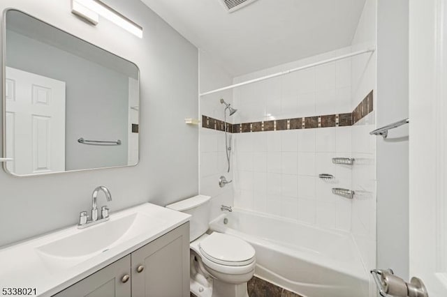 full bathroom featuring tiled shower / bath combo, vanity, and toilet