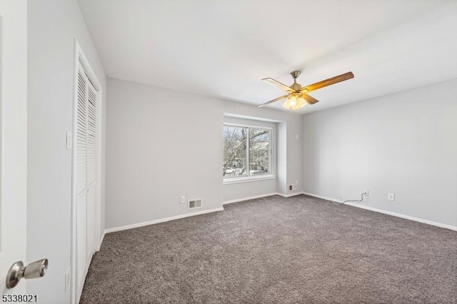 unfurnished bedroom featuring dark colored carpet, ceiling fan, and a closet