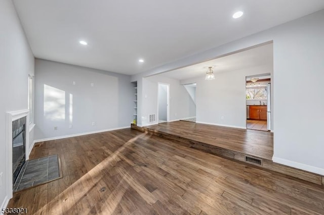 unfurnished living room with wood-type flooring and a fireplace