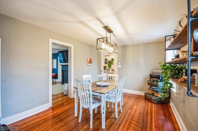 dining space featuring hardwood / wood-style floors and an inviting chandelier