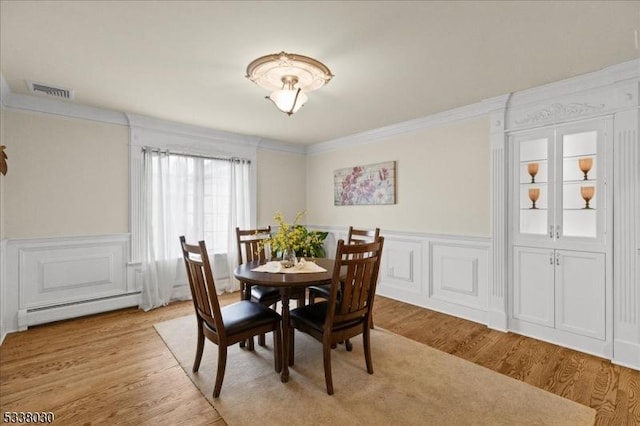 94 Brookville Hollow Rd, Delaware Twp, NJ 08559 - dining room featuring a decorative wall, a baseboard heating unit, wainscoting, and light wood-type flooring