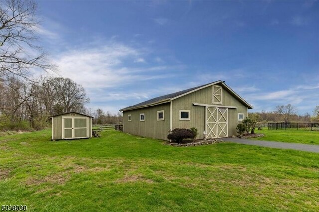 94 Brookville Hollow Rd, Delaware Twp, NJ 08559 - view of property exterior with fence, a barn, a shed, a lawn, and an outbuilding