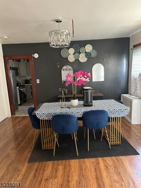 dining room with hardwood / wood-style floors and a chandelier