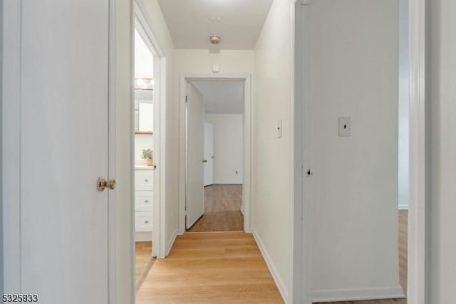 hall featuring baseboards and light wood-style floors