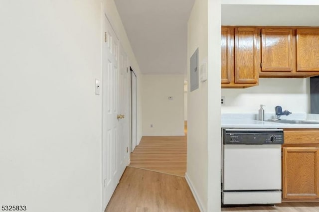 kitchen featuring brown cabinetry, light wood-style flooring, a sink, light countertops, and dishwasher