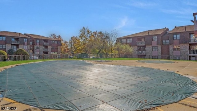 community pool with a residential view, a patio, and fence