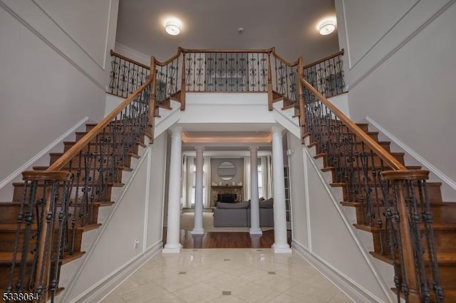 foyer entrance featuring a towering ceiling and decorative columns