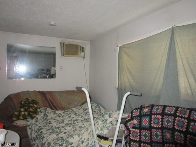 bedroom with a wall unit AC and a textured ceiling