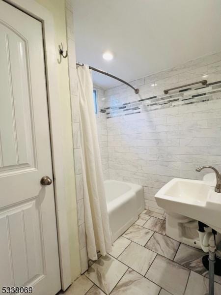 bathroom with shower / bathtub combination with curtain and tile walls