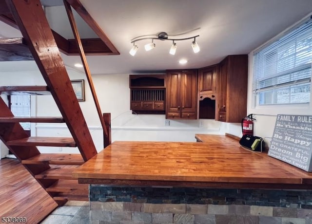 bar featuring wood counters, wood-type flooring, and track lighting