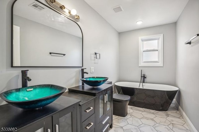 bathroom featuring vanity, toilet, and a bathing tub