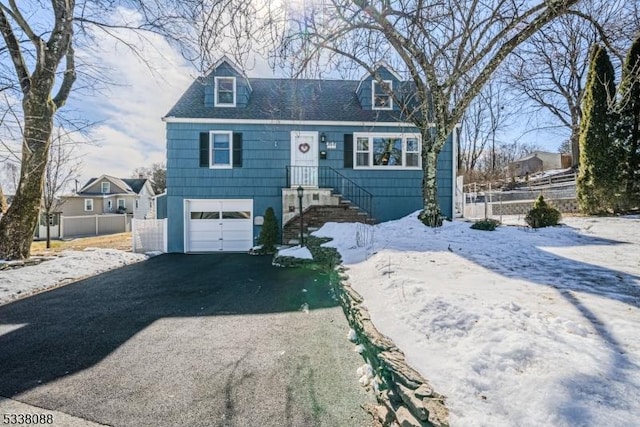 cape cod home with a garage, fence, driveway, and a shingled roof