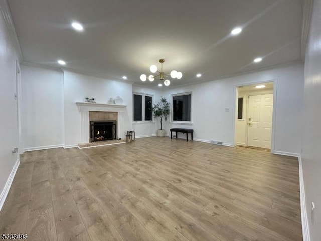 unfurnished living room with recessed lighting, visible vents, a warm lit fireplace, and light wood-style flooring