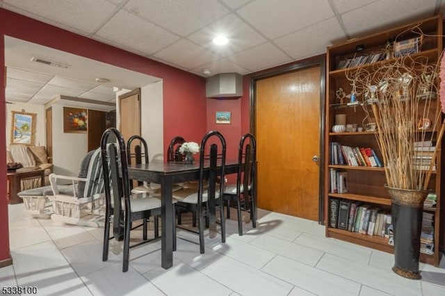 dining space with a paneled ceiling and visible vents