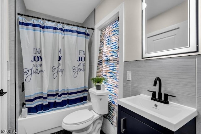 full bathroom featuring vanity, tile walls, shower / tub combo with curtain, and toilet