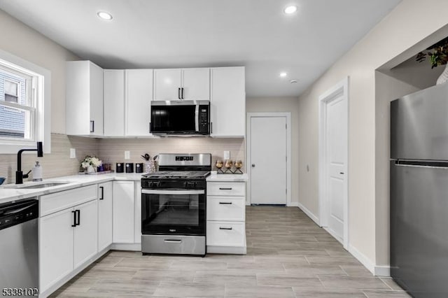 kitchen featuring white cabinetry, sink, decorative backsplash, and appliances with stainless steel finishes