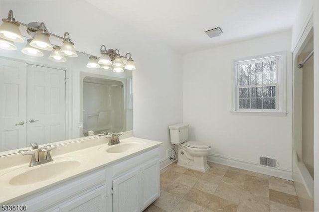 bathroom featuring vanity, a shower, and toilet