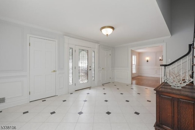 entryway featuring crown molding and a wealth of natural light