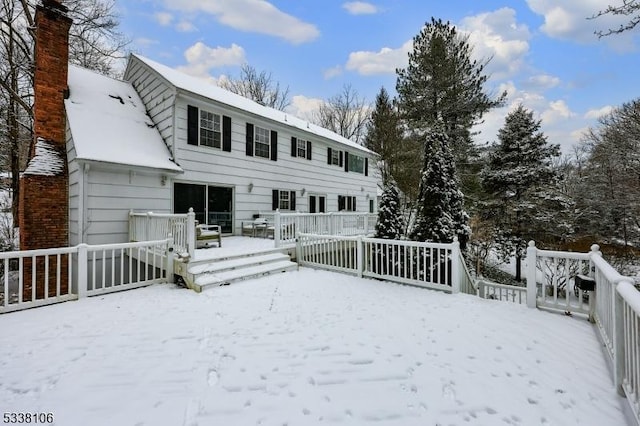 snow covered rear of property featuring a wooden deck