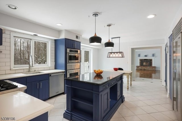 kitchen with a kitchen island, blue cabinets, dishwasher, sink, and decorative backsplash