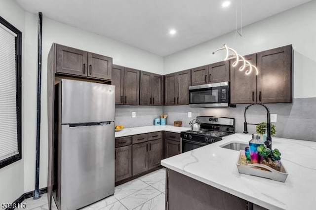 kitchen with dark brown cabinetry, appliances with stainless steel finishes, sink, and backsplash