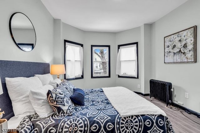 bedroom with hardwood / wood-style flooring and radiator heating unit