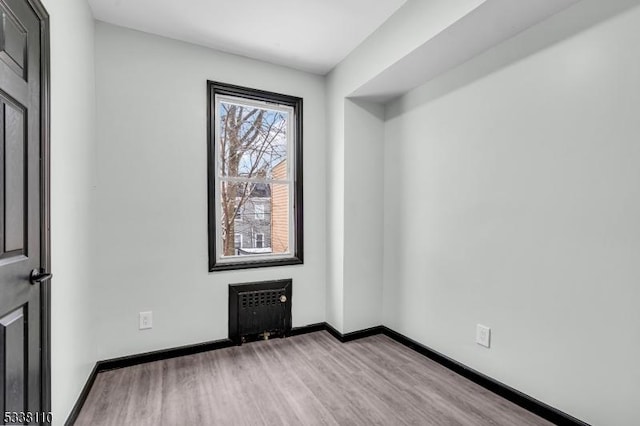 spare room with radiator and light hardwood / wood-style flooring