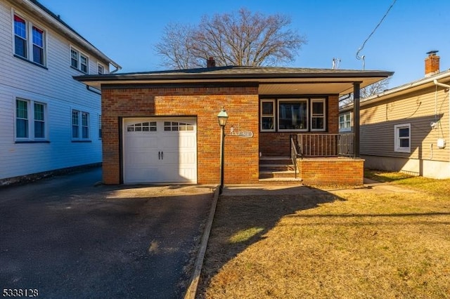 view of front of home featuring a garage, brick siding, a porch, and driveway