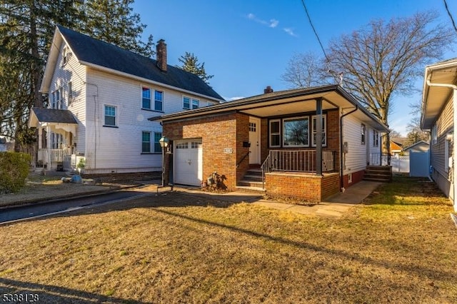 view of front of home with a front lawn, brick siding, and an attached garage