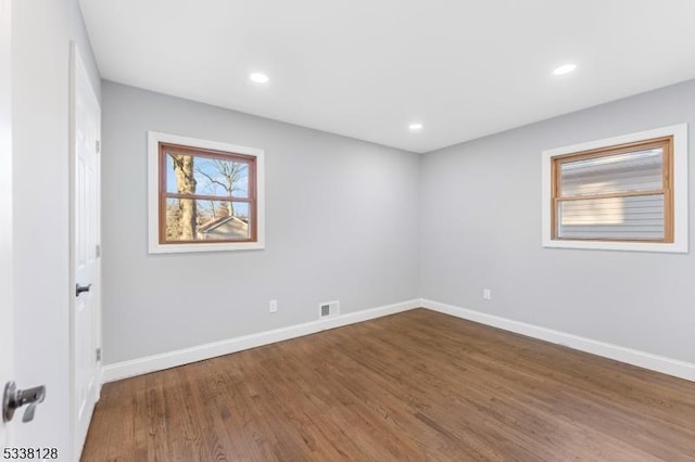 unfurnished room with dark wood-type flooring, recessed lighting, visible vents, and baseboards