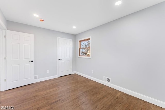 unfurnished bedroom featuring recessed lighting, visible vents, baseboards, and wood finished floors