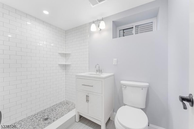 full bath with visible vents, toilet, a stall shower, vanity, and baseboards