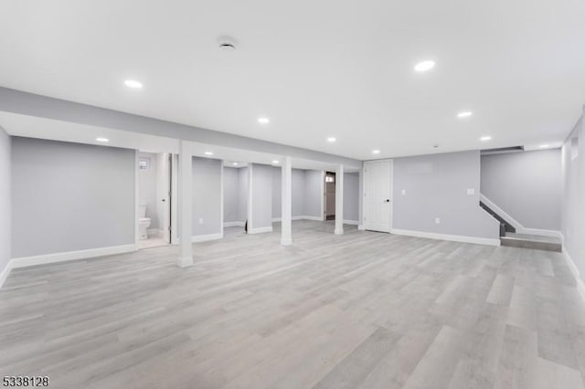 finished below grade area featuring light wood-type flooring, baseboards, and recessed lighting