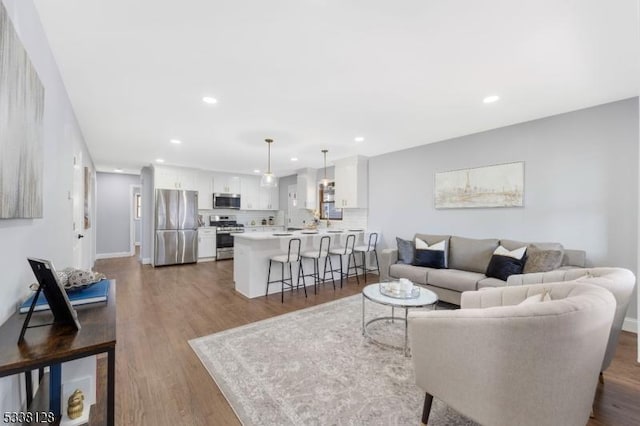 living area with recessed lighting, baseboards, and wood finished floors