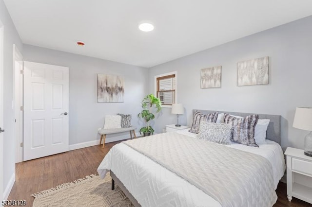 bedroom with baseboards and wood finished floors