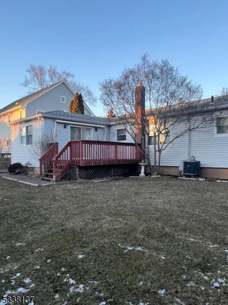 rear view of property with central AC, a wooden deck, and a yard