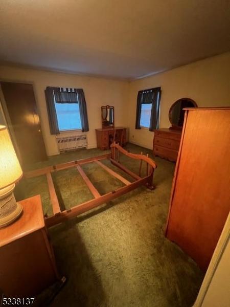 carpeted bedroom featuring radiator heating unit