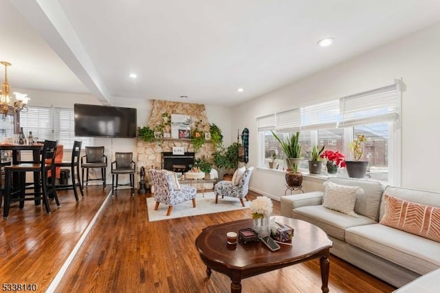 living room with hardwood / wood-style flooring, beamed ceiling, a chandelier, and a healthy amount of sunlight