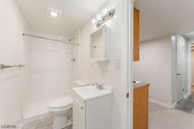 bathroom with toilet, vanity, and walk in shower