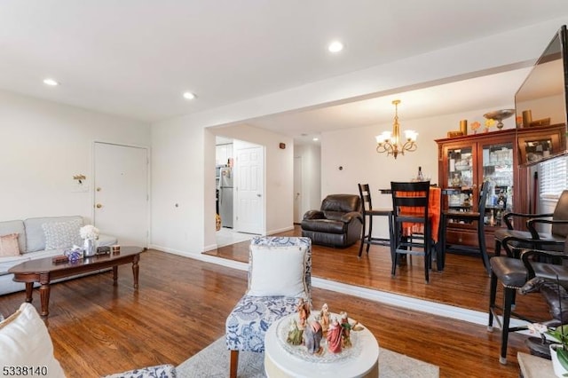 living room with a notable chandelier and dark hardwood / wood-style floors