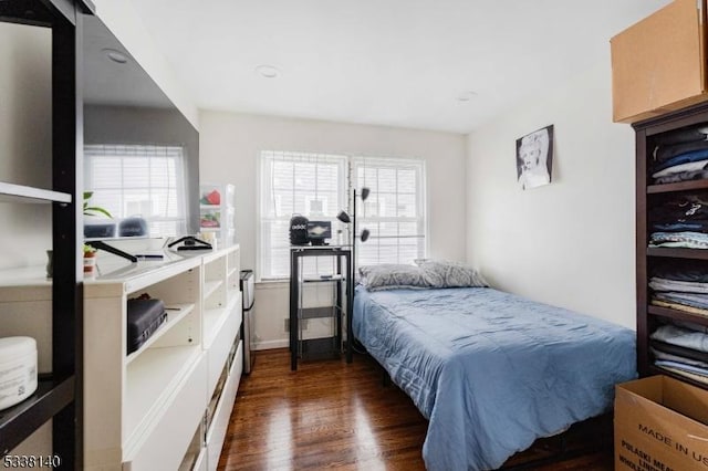 bedroom with multiple windows and dark hardwood / wood-style flooring