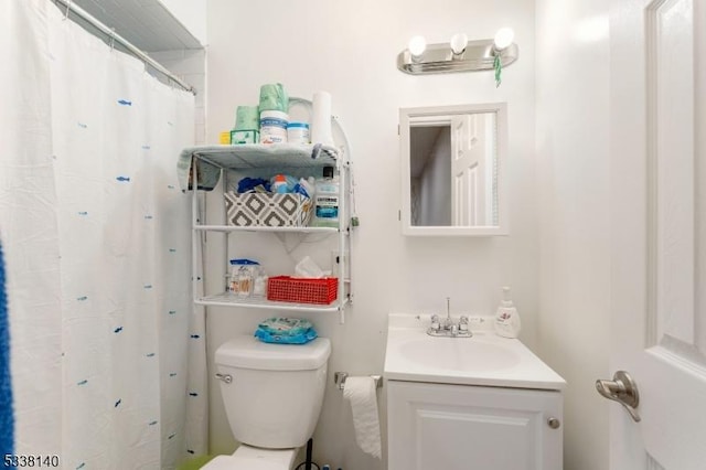 bathroom featuring toilet, vanity, and a shower with shower curtain